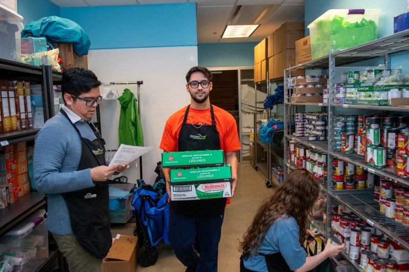 Three student volunteers stock the shelves at the UFV-SUS foodbank