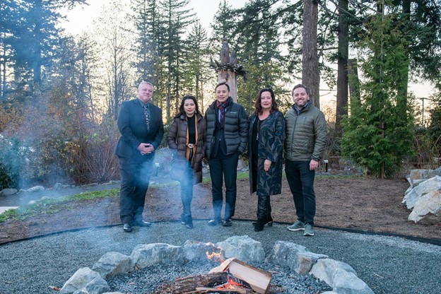 A group of people standing in front of a firepit.