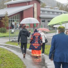 Guest arrive at UFV's Agricultural Centre of Excellence for the Celebration of Community. They're holding umbrellas but cheerful in the rain.